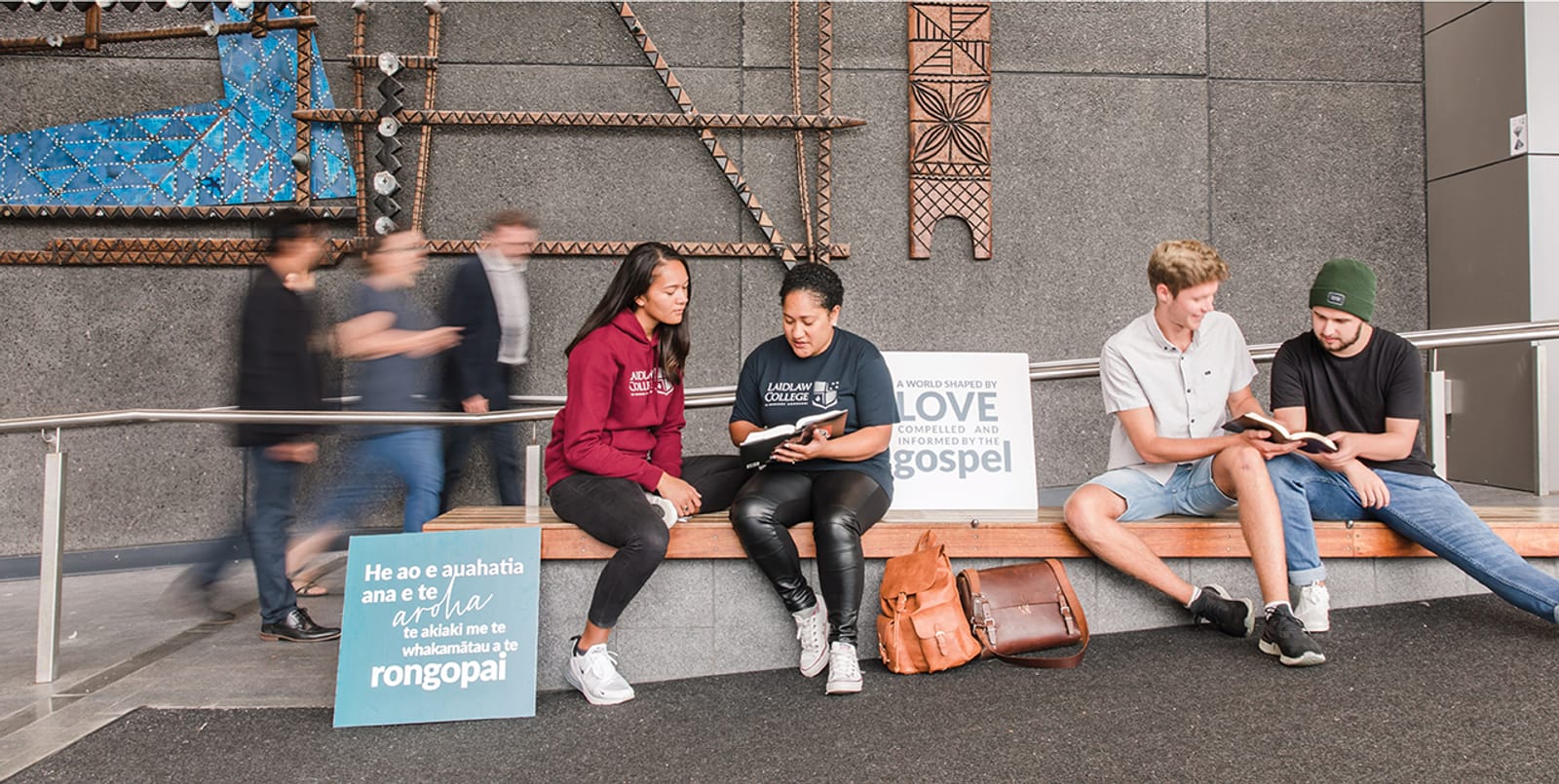 Laidlaw students reading together beside tukutuku panels